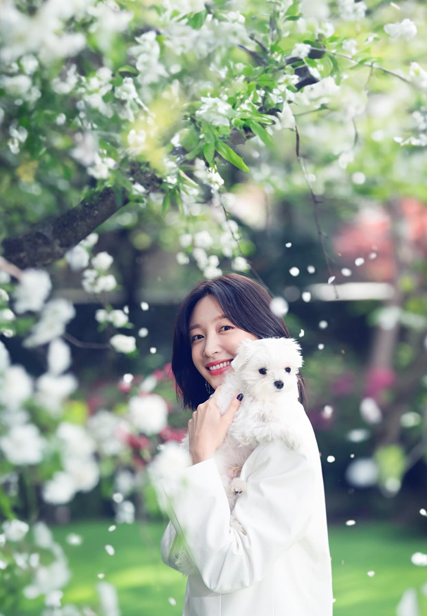 Hani EXID อุ้มสุนัขสีขาวท่ามกลางสวนดอกไม้