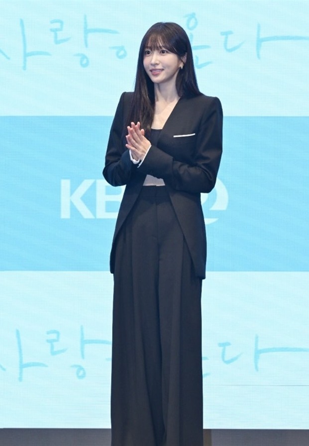 Hani EXID ในชุดสูทสีดำบนเวทีงานแถลงข่าว Love Is Coming